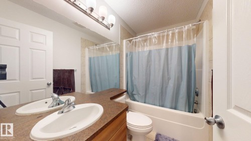 Bathroom with vanity, a textured ceiling, and shower / bathtub combination with curtain - 1030 177A Street, Edmonton, AB - Indoor Photo Showing Bathroom