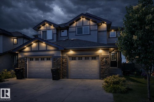 Craftsman house featuring concrete driveway, stone siding, board and batten siding, roof with shingles, and an attached garage - 1030 177A Street, Edmonton, AB - Outdoor With Facade