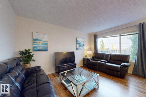 Living room featuring a textured ceiling and wood finished floors - 1030 177A Street, Edmonton, AB - Indoor Photo Showing Living Room