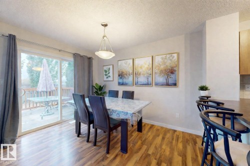Dining area with a textured ceiling and light wood-style flooring - 1030 177A Street, Edmonton, AB - Indoor Photo Showing Dining Room