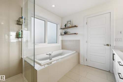 Full bath featuring a bath, a stall shower, vanity, and light tile patterned floors - 30 Willow Link, Fort Saskatchewan, AB - Indoor Photo Showing Bathroom