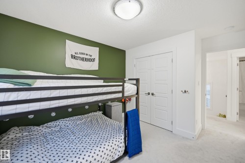 Bedroom with light colored carpet, a closet, and a textured ceiling - 30 Willow Link, Fort Saskatchewan, AB - Indoor Photo Showing Bedroom