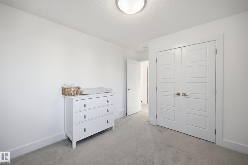 Bedroom with light colored carpet, a closet, and a textured ceiling - 30 Willow Link, Fort Saskatchewan, AB - Indoor