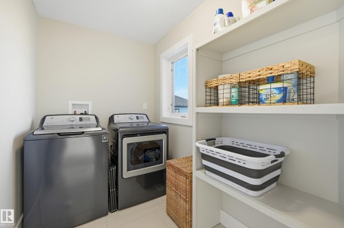 Laundry room featuring washing machine and dryer and light tile patterned floors - 30 Willow Link, Fort Saskatchewan, AB - Indoor Photo Showing Laundry Room