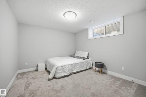 Carpeted bedroom with baseboards and a textured ceiling - 30 Willow Link, Fort Saskatchewan, AB - Indoor Photo Showing Bedroom