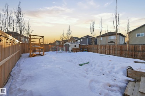 Yard covered in snow featuring a residential view, a shed, and a fenced backyard - 30 Willow Link, Fort Saskatchewan, AB - Outdoor