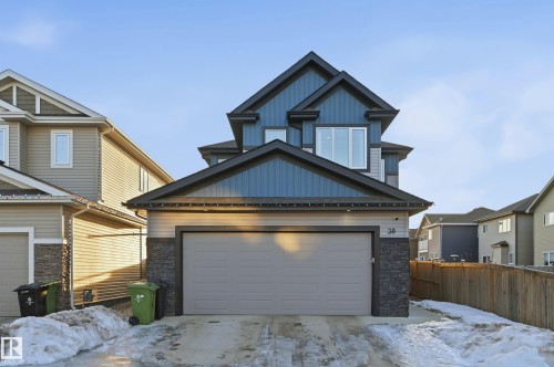 Craftsman inspired home with stone siding, a garage, board and batten siding, and driveway - 30 Willow Link, Fort Saskatchewan, AB - Outdoor