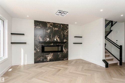 Unfurnished living room with parquet flooring, a fireplace, recessed lighting, and plenty of natural light - 3248 Pelerin Crescent, Beaumont, AB - Indoor With Fireplace