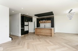 Kitchen featuring a center island with sink, two tone color scheme, parquet floors, recessed lighting, and modern cabinets - 