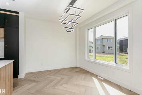 Unfurnished dining area featuring parquet flooring and baseboards - 3248 Pelerin Crescent, Beaumont, AB - Indoor Photo Showing Other Room