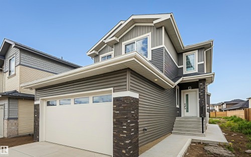 View of side of property with driveway, a garage, and board and batten siding - 3248 Pelerin Crescent, Beaumont, AB - Outdoor