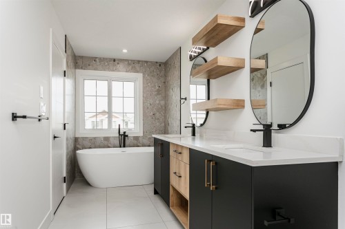 Full bath featuring double vanity, a soaking tub, and tile walls - 3248 Pelerin Crescent, Beaumont, AB - Indoor Photo Showing Bathroom