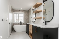 Full bath featuring double vanity, a soaking tub, and tile walls - 