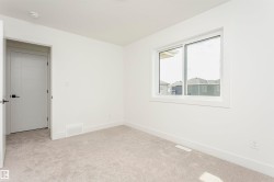 Unfurnished bedroom with light carpet and baseboards - 