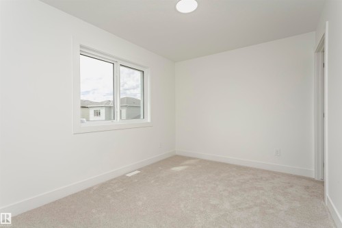 Spare room featuring baseboards and light carpet - 3248 Pelerin Crescent, Beaumont, AB - Indoor Photo Showing Other Room