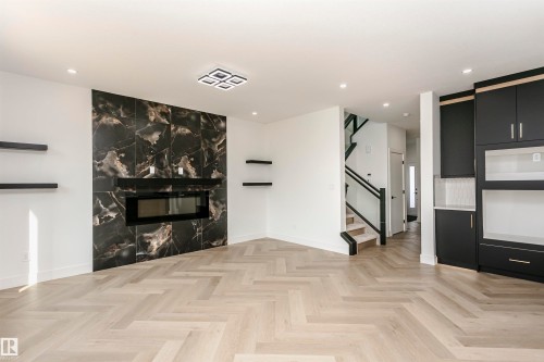 Unfurnished living room featuring parquet floors, recessed lighting, and a fireplace - 3248 Pelerin Crescent, Beaumont, AB - Indoor With Fireplace