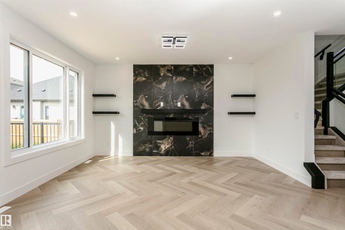 Unfurnished living room with parquet flooring, recessed lighting, and a fireplace - 3248 Pelerin Crescent, Beaumont, AB - Indoor Photo Showing Living Room With Fireplace