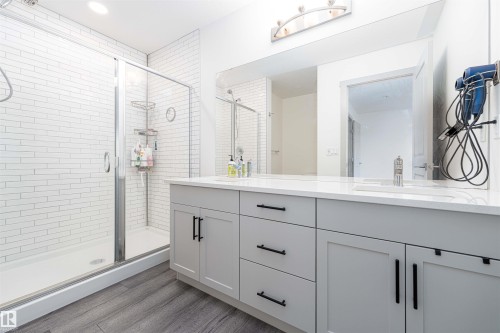 Full bathroom with double vanity, a stall shower, and light wood-type flooring - 2330 Kelly Circle, Edmonton, AB - Indoor Photo Showing Bathroom