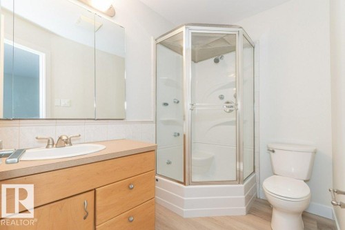 Full bathroom with vanity, light wood finished floors, and bath / shower combo with glass door - 5720 109A Street Nw, Edmonton, AB - Indoor Photo Showing Bathroom