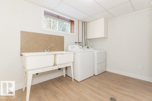Laundry area with a paneled ceiling, light wood finished floors, and separate washer and dryer - 5720 109A Street Nw, Edmonton, AB - Indoor Photo Showing Laundry Room