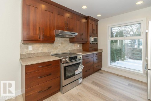 Kitchen featuring stainless steel appliances, decorative backsplash, light wood-style flooring, recessed lighting, and wood finish cabinetry - 5720 109A Street Nw, Edmonton, AB - Indoor Photo Showing Kitchen