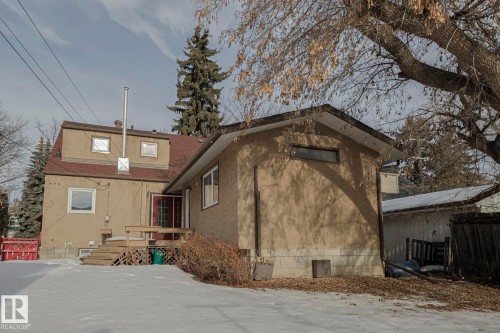 View of snow covered exterior with a deck, roof with shingles, and stucco siding - 11507 72 Avenue Nw, Edmonton, AB - Outdoor