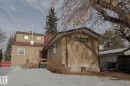 View of snow covered exterior with a deck, roof with shingles, and stucco siding - 11507 72 Avenue Nw, Edmonton, AB  - Outdoor 
