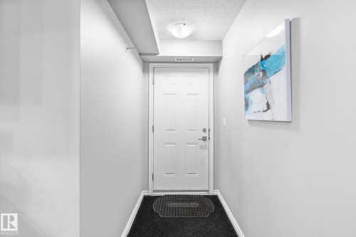 Doorway to outside featuring a textured ceiling and carpet flooring - 301 10118 106 Avenue, Edmonton, AB - Indoor Photo Showing Other Room