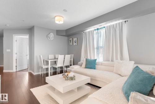 Living room featuring dark wood-style flooring and a textured ceiling - 301 10118 106 Avenue, Edmonton, AB - Indoor Photo Showing Living Room