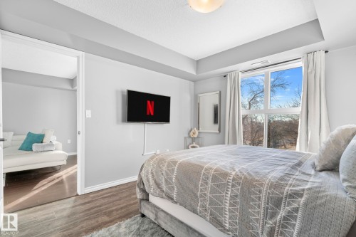 Bedroom with wood finished floors and a raised ceiling - 301 10118 106 Avenue, Edmonton, AB - Indoor Photo Showing Bedroom
