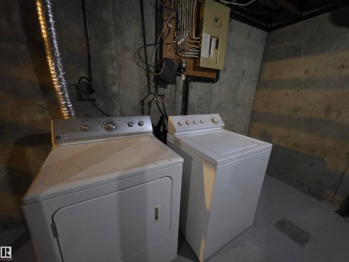 Laundry area with electric panel, washer and dryer, and concrete floors - Edmonton, AB - Indoor Photo Showing Laundry Room
