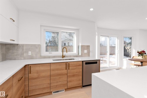 Two tone kitchen with dishwasher, modern cabinets, light stone counters, plenty of natural light, and recessed lighting - 607 Butterworth Wynd, Edmonton, AB - Indoor Photo Showing Kitchen