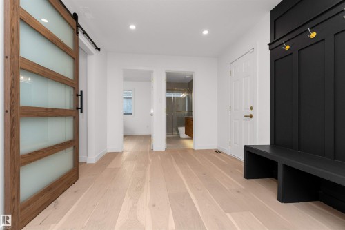 Mudroom featuring a barn door, light wood-type flooring, and recessed lighting - 607 Butterworth Wynd, Edmonton, AB - Indoor Photo Showing Other Room
