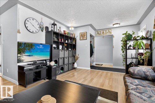 Living area with light wood-type flooring and a textured ceiling - 13320 123 Street, Edmonton, AB - Indoor