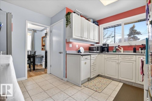 Kitchen with white cabinetry, stainless steel appliances, and light tile patterned floors - 13320 123 Street, Edmonton, AB - Indoor