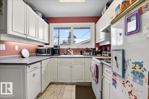 Kitchen with white appliances, white cabinets, and light tile patterned floors - 13320 123 Street, Edmonton, AB - Indoor Photo Showing Kitchen