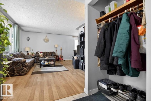 Living room featuring a textured ceiling and light wood-style flooring - 13320 123 Street, Edmonton, AB - Indoor