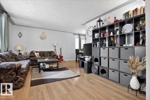 Living area featuring light wood finished floors and a textured ceiling - 13320 123 Street, Edmonton, AB - Indoor Photo Showing Other Room