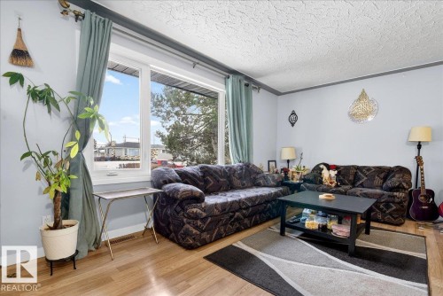 Living room with wood finished floors and a textured ceiling - 13320 123 Street, Edmonton, AB - Indoor Photo Showing Living Room