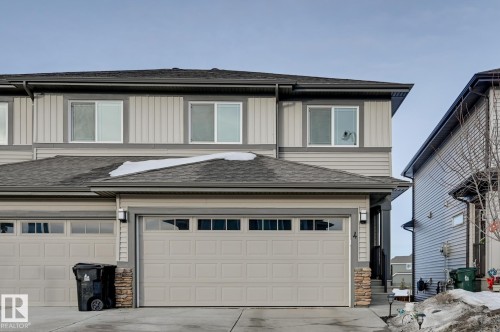 View of front of home with roof with shingles, stone siding, board and batten siding, and concrete driveway - 4 Caledon Crescent, Spruce Grove, AB - Outdoor