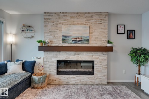 Living area with a fireplace and wood finished floors - 4 Caledon Crescent, Spruce Grove, AB - Indoor Photo Showing Living Room With Fireplace