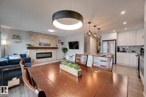 Dining space featuring a stone fireplace, light wood-type flooring, and recessed lighting - 4 Caledon Crescent, Spruce Grove, AB - Indoor With Fireplace