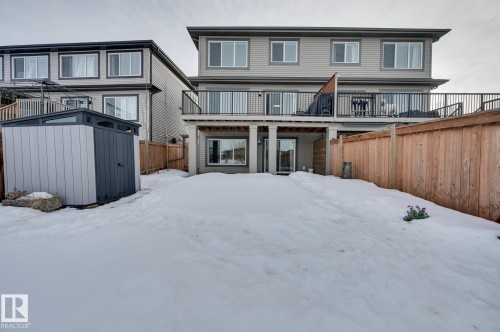 Snow covered house featuring a fenced backyard, a storage shed, and a wooden deck - 4 Caledon Crescent, Spruce Grove, AB - Outdoor With Deck Patio Veranda