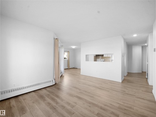 Unfurnished living room featuring baseboard heating, light wood-style flooring, and recessed lighting - 108 5065 31 Avenue, Edmonton, AB - Indoor Photo Showing Other Room