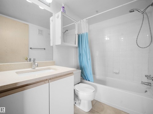 Full bath featuring vanity, shower / bath combo with shower curtain, and light tile patterned floors - 108 5065 31 Avenue, Edmonton, AB - Indoor Photo Showing Bathroom