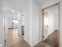 Corridor featuring light wood-style floors, a textured ceiling, and a baseboard heating unit - 108 5065 31 Avenue, Edmonton, AB  - Indoor Photo Showing Other Room 