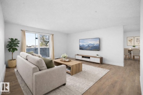 Living room with wood finished floors and a textured ceiling - 108 5065 31 Avenue, Edmonton, AB - Indoor Photo Showing Living Room