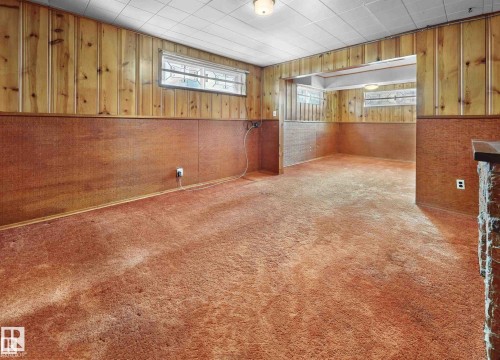 Empty room featuring wooden walls, carpet, and wainscoting - 11127 71 Avenue, Edmonton, AB - Indoor Photo Showing Other Room