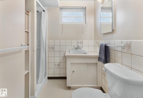 Bathroom featuring a stall shower, vanity, and tile walls - 11127 71 Avenue, Edmonton, AB - Indoor Photo Showing Bathroom