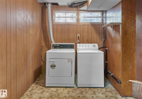 Laundry area featuring wood walls and washer and dryer - 11127 71 Avenue, Edmonton, AB - Indoor Photo Showing Laundry Room